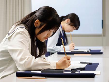 　「原爆死没者名簿」に被爆者の氏名や年齢を書き込む一般公募で選ばれた記帳者＝７日午後、広島市