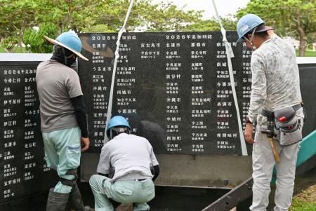 　石碑「平和の礎」に刻銘板を設置する作業員＝１８日午前、沖縄県糸満市摩文仁の平和祈念公園