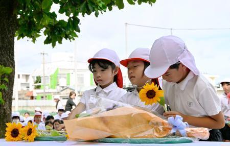 　沖縄県うるま市の宮森小で献花する児童たち＝３０日午前