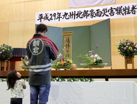 　２０１７年の九州北部の豪雨から９年となり、被害が大きかった福岡県朝倉市松末地区に設置された献花台に花を手向ける住民＝５日午前