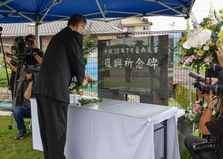 　西日本豪雨から８年となり、愛媛県西予市に設置された献花台に花を手向ける管家一夫市長＝７日午前