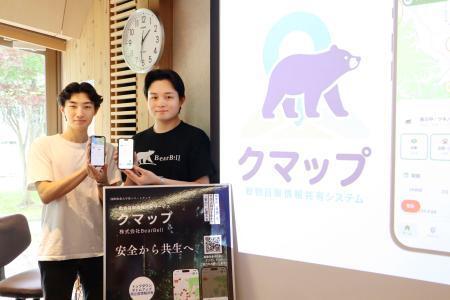 　クマの目撃情報をリアルタイムで共有できるスマートフォンアプリ「クマップ」をリリースした「ＢｅａｒＢｅｌｌ」の服部悠大さん（右）＝１３日午後、秋田市の国際教養大