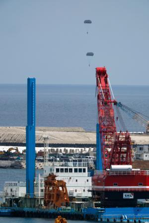 　米海兵隊が沖縄県名護市辺野古沖で実施したパラシュート降下訓練。手前は米軍普天間飛行場の移設に向けた工事が進む大浦湾＝２１日午後