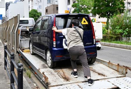 　水に漬かり動かなくなった車両を押す所有者の男性＝１７日午後、千葉市中央区