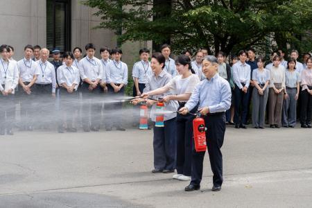 　宮内庁が実施した消火訓練に参加され、水が入った消火器を噴射する天皇、皇后両陛下と愛子さま＝１日午前、皇居（宮内庁提供）