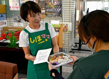 　熊本県氷川町役場でひとり親に弁当を手渡す柳原志保さん＝８月