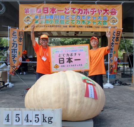 　「日本一どでカボチャ大会」で優勝した田辺憲明さん（左）と３位に入った孫の響人さん＝１３日正午ごろ、香川県土庄町