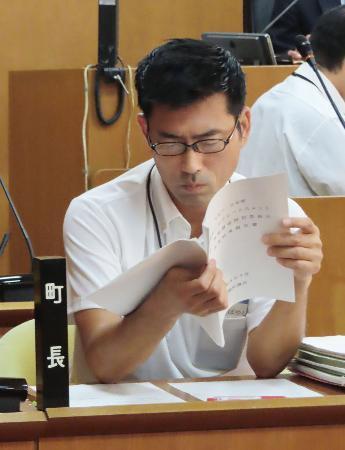 　議会で報告書を読む神奈川県真鶴町の小林伸行町長＝１８日午前