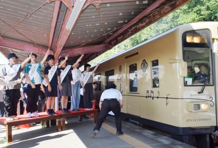 　「くま川鉄道」が全線で運行を再開し、地元の小学生たちの合図で人吉温泉駅を出発する記念特別列車＝２０日午前、熊本県人吉市
