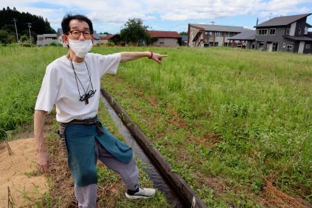 　クマに襲われた空き地を指す千葉清美さん＝８月、秋田県仙北市
