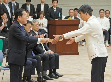 　パリ五輪・パラリンピック日本選手団と面会し、五輪選手団の尾県貢団長（右）に感謝状を授与する岸田首相＝１１日午前、首相官邸