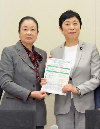 　選択的夫婦別姓を巡り、自民党の推進派議員連盟の土屋品子会長代行（左）に、民法改正案要綱を手渡す立憲民主党の辻元清美代表代行＝１５日午後、国会