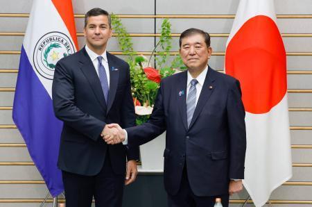 　会談を前に握手するパラグアイのペニャ大統領（左）と石破首相＝２１日夜、首相官邸