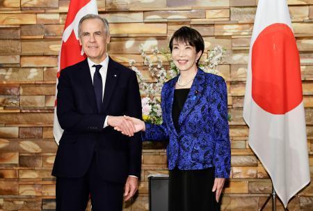 　会談を前に握手するカナダのカーニー首相（左）と高市首相＝６日午後、首相官邸