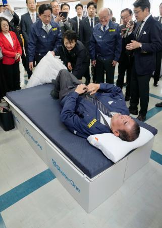 　災害備蓄品の展示会で、段ボールベッドに横になる石破前首相＝９日午前、東京・永田町の自民党本部