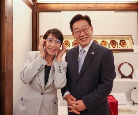 　内閣広報室のＸ（旧ツイッター）に１９日に投稿された、韓国の李在明大統領（右）愛用の眼鏡をすかさず「拝借」する高市首相の写真