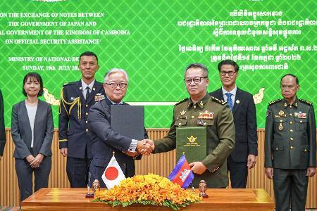 　カンボジアの首都プノンペンで開かれた署名式に出席する植野篤志駐カンボジア大使（手前左）とティア・セイハ副首相兼国防相（手前右）＝１９日（外務省提供）