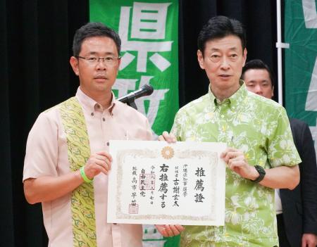 　推薦証を手に写真に納まる自民党の西村選対委員長（右）と元那覇市副市長の古謝玄太氏＝２０日午後、沖縄県浦添市