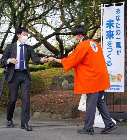 　福島県知事選の投票を呼びかける県選挙管理委の職員（右）＝１４日午前、福島市