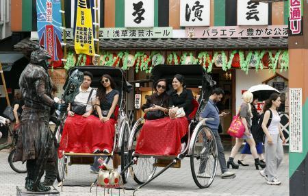 　東京・浅草で人力車を楽しむ外国人観光客。周辺では多くの訪日客が行き交っていた＝７月