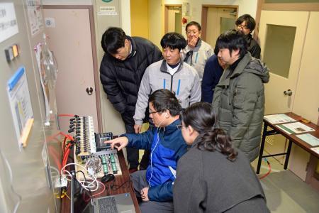 　放射線防護施設で測定した気圧を確認する研究チーム＝１４日午後、新潟県柏崎市