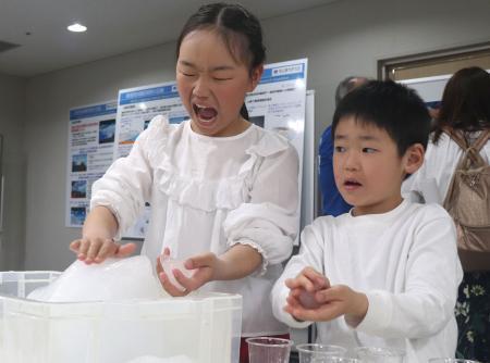　南極について学ぶイベントで、氷に触れる子どもたち＝２１日午後、広島市中区
