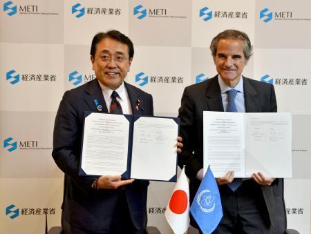 　覚書を締結した赤沢経産相（左）とＩＡＥＡのグロッシ事務局長＝２３日午後、経産省