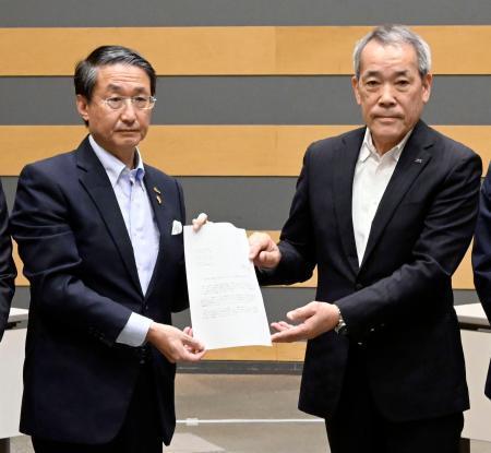 　中国電力から島根原発２号機のプルサーマル発電についての文書を受け取る平井伸治鳥取県知事（左）＝２４日午前、鳥取県境港市