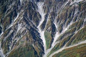 　氷河と確認された、長野県白馬村の白馬沢雪渓（中央の谷の上部）＝２０１８年１０月（奈良間研究室提供）