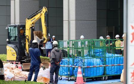 　さいたま新都心合同庁舎１号館で、花壇に除染土を運ぶ作業員ら＝３０日午前、さいたま市
