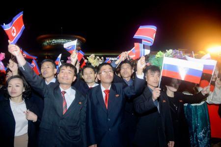　２０２３年１０月、平壌国際空港で北朝鮮とロシアの国旗を振る人たち（共同）
