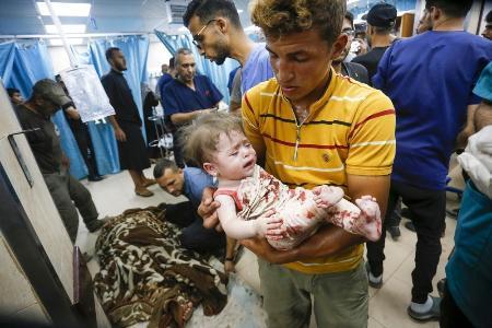 　８日、ガザ中部デールバラハの病院に運ばれるパレスチナ人の子どもら（ゲッティ＝共同）