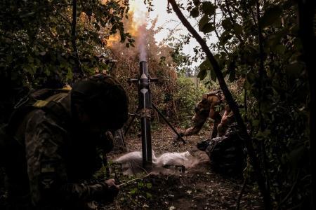 　１５日、ウクライナ東部ドネツク州で、ロシア側に向けて砲撃するウクライナ軍兵士（ロイター＝共同）