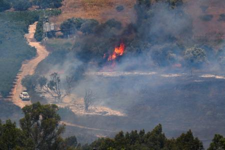 　レバノン側からの攻撃後、炎が上がるイスラエル側の国境地帯＝１８日（ロイター＝共同）