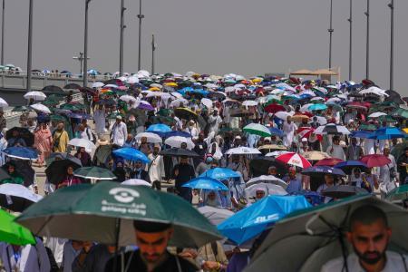 　１８日、サウジアラビア・メッカ近郊で日差しを避けるため傘を差す巡礼者ら（ＡＰ＝共同）