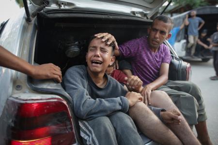　２４日、パレスチナ自治区ガザ南部ハンユニスで、イスラエル軍の空爆で親族を亡くし、泣く住民（ＡＰ＝共同）