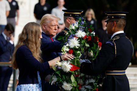 　米アーリントン国立墓地で開かれた献花式に遺族と参列したトランプ前大統領（左から２人目）＝２６日、バージニア州（ゲッティ＝共同）