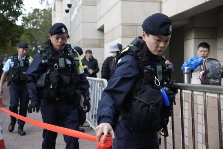 　蘋果日報の創業者、黎智英氏の情状酌量を審理する公判前、裁判所周辺を警戒する警察官＝１２日、香港（共同）