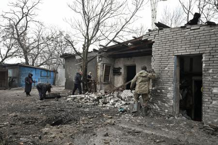 　６日、ウクライナ南部ザポリージャで、ロシア軍の攻撃後のがれきを片付けるボランティアら（ロイター＝共同）