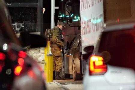 イスラエルとヨルダン川西岸を隔てる検問所で通行する車を調べるイスラエル兵＝２０２５年２月（共同）