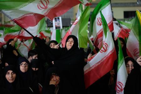 　１７日、イラン体制側がテヘランで催した反政府デモの死者の追悼式典で、国旗を振る女性ら（ＡＰ＝共同）