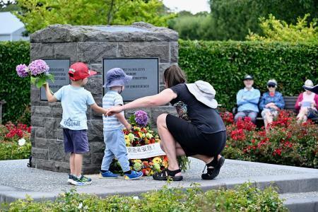 　ニュージーランド地震の犠牲者をしのぶ追悼式で、花を手向ける人たち＝２０日、クライストチャーチ（共同）