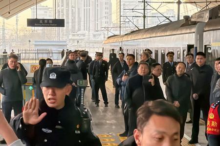 　北京駅で出発を待つ平壌行きの旅客列車と警戒する治安当局者＝１２日（共同）