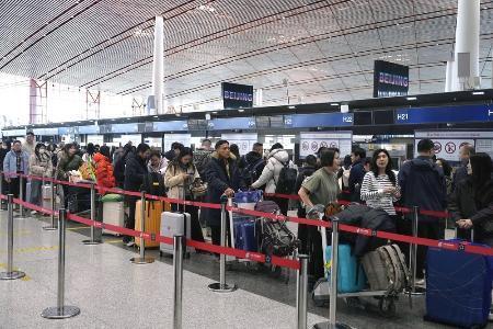 　春節に合わせた大型連休の初日、北京首都国際空港で日本便などをあつかうカウンターにならぶ人たち＝２月１５日