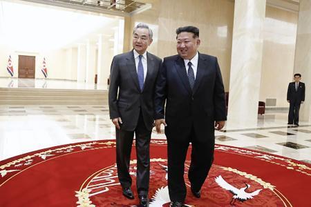 　訪朝した中国の王毅外相（左）と歩く北朝鮮の金正恩朝鮮労働党総書記＝１０日、平壌（中国外務省のホームページから・共同）