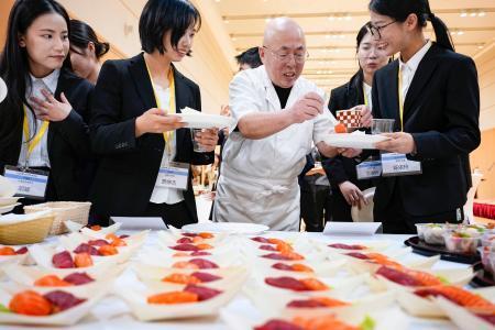 　ＪＥＴプログラムの壮行会で寿司を手にする参加者ら＝１１日、北京の日本大使館（共同）