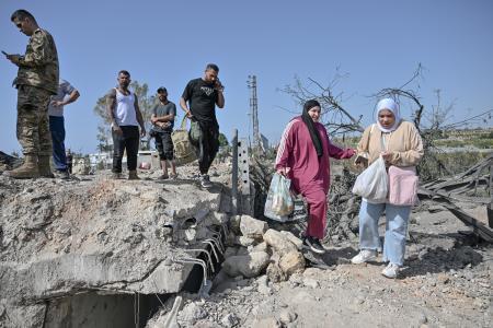 　イスラエルの攻撃で破壊された橋を渡ろうとする人々＝１６日、レバノン南部スール近郊（ゲッティ＝共同）