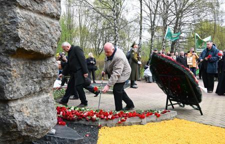 　２６日、ベラルーシ・ミンスクの追悼碑に花を手向ける「チェルノブイリ功労者の会」の人々（共同）