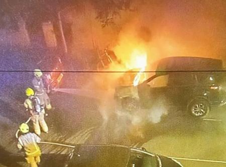 　２０２５年５月、放火されて燃える車。スターマー英首相が過去に所有していた＝ロンドン（住民提供・共同）