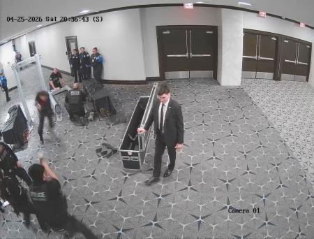 　暗殺未遂事件のあったホテルで安全検査場を走り抜けるアレン容疑者に発砲する警備要員（手前左）＝４月２５日、ワシントン（ピロ連邦検事のＸから、ロイター＝共同）